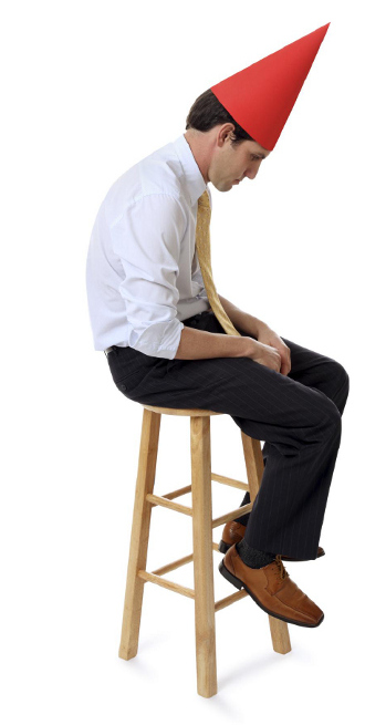Sad man wearing dunce cap.